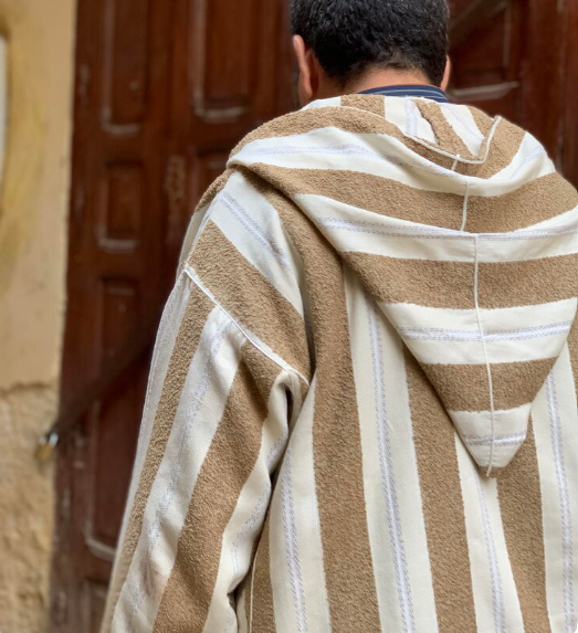 Moroccan Men’s Djellaba: 2025 Man in white Moroccan men’s djellaba and sunglasses standing confidently, representing traditional North African clothing and cultural identity.