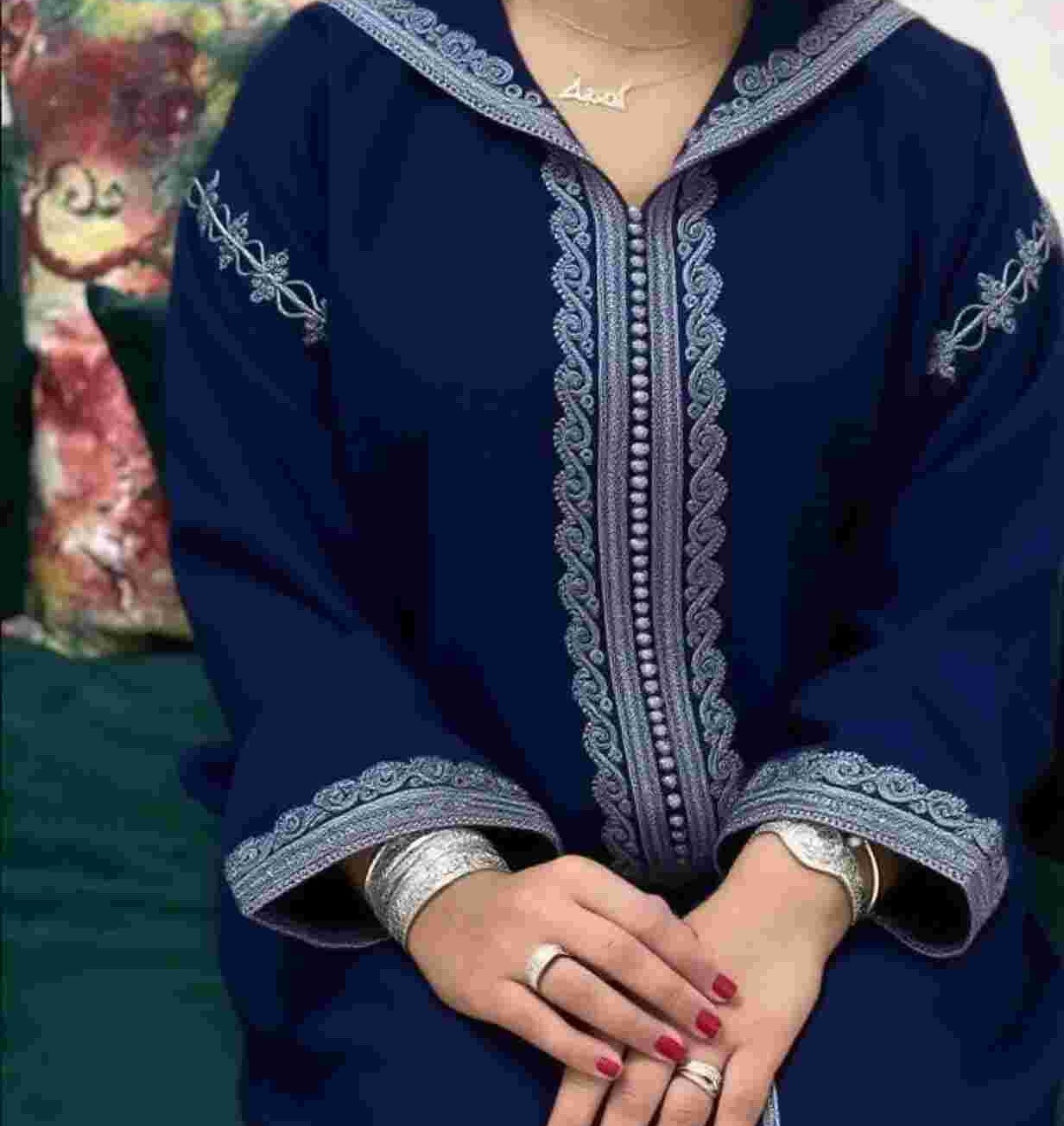 Moroccan woman wearing a traditional embroidered djellaba with a hood